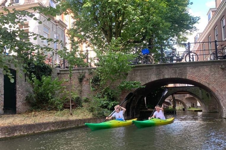 Kano’s varen onder een oude brug door