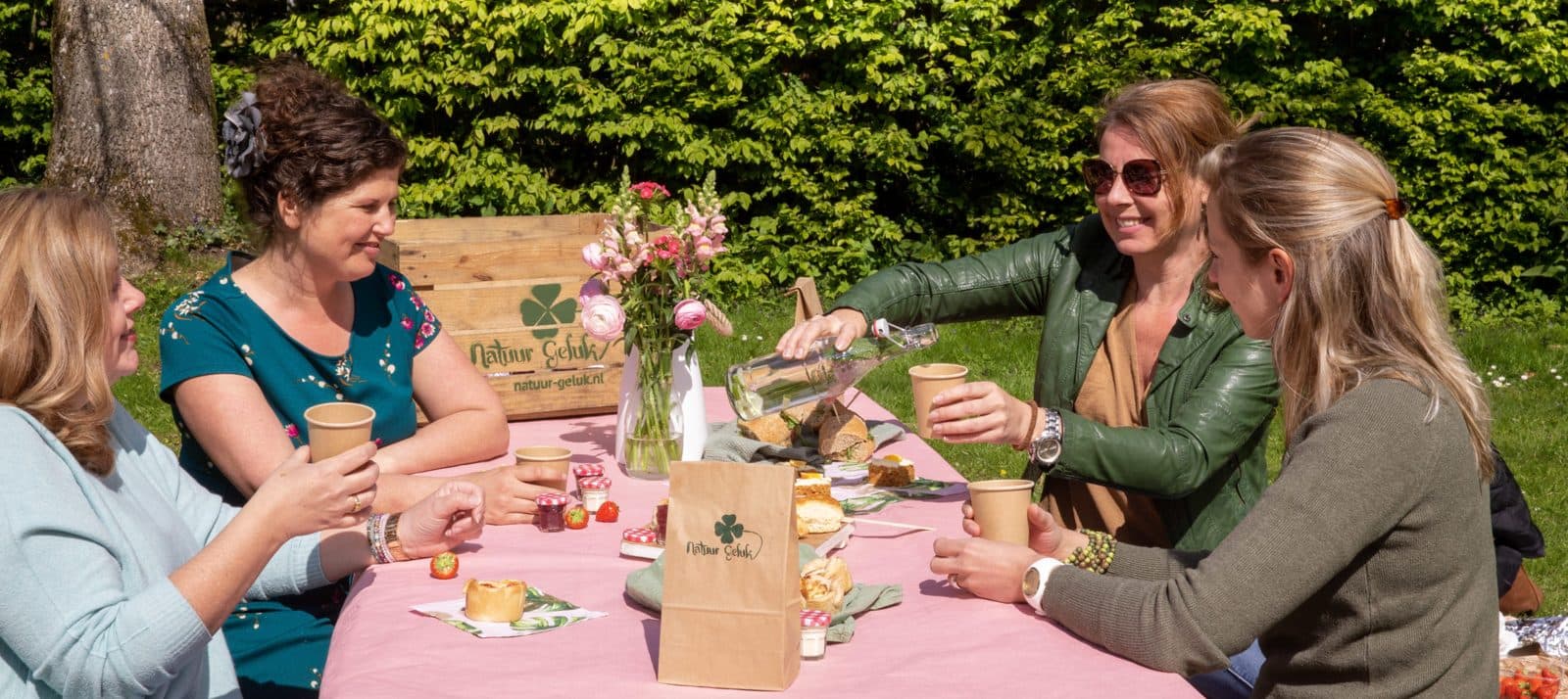 Groep aan een gedekte picknicktafel in het gras