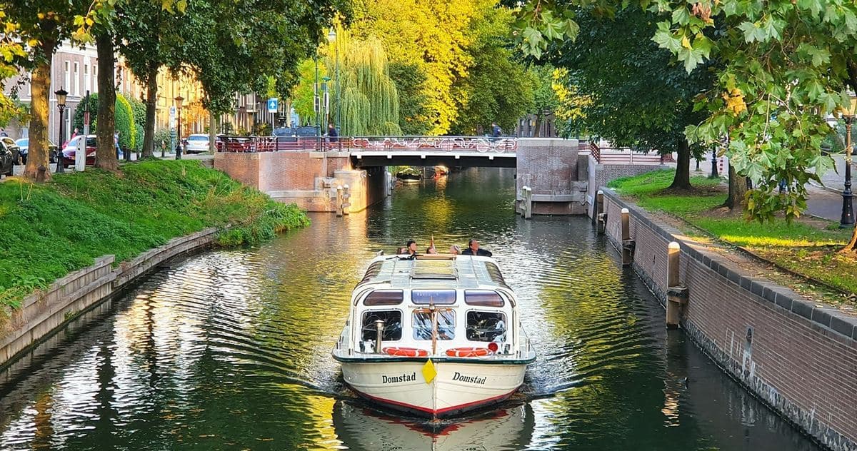Rondvaartboot op een Utrechtse gracht tussen de bomen