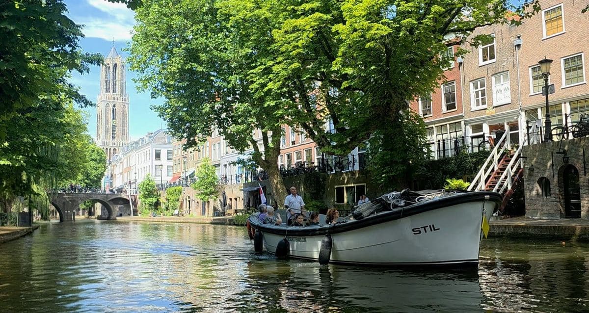 Open sloep op de Oudegracht met de Domtoren op de achtergrond