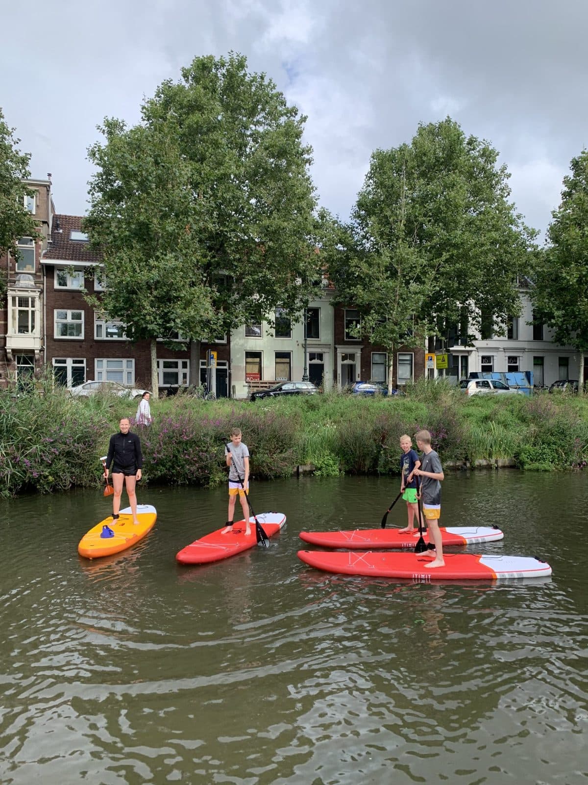 Paddlers with red boards at the water’s edge